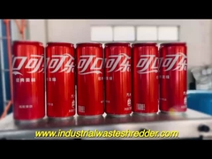 La tritare a doppio albero trita bottiglie di plastica di cola scadute e difettose.